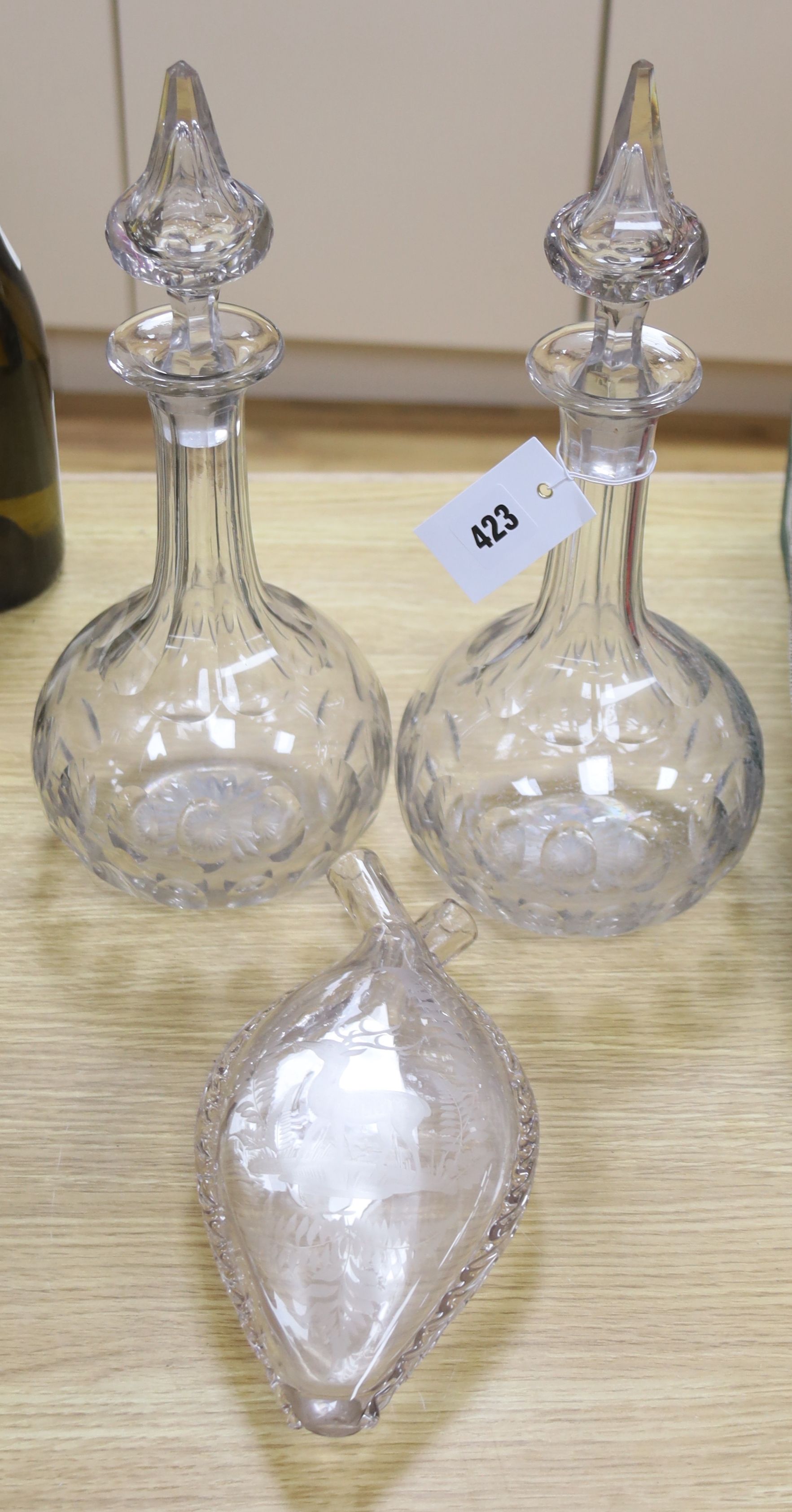 A pair of panel cut clear glass decanters , 36cm high and a wheel engraved glass flask, dated 1886, 24cm high (3)